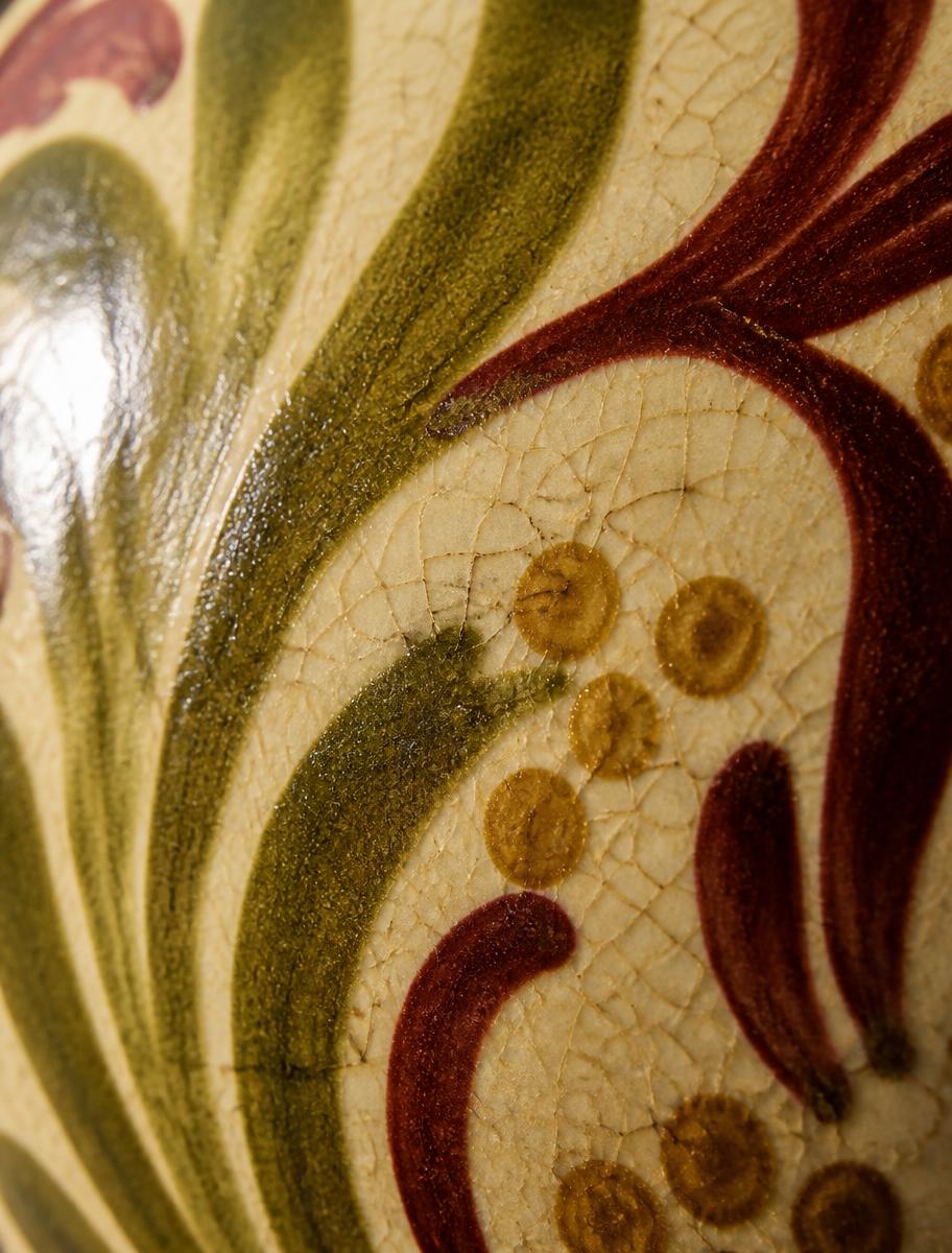 Close crop of olive and burgundy pattern on glazed ceramic
